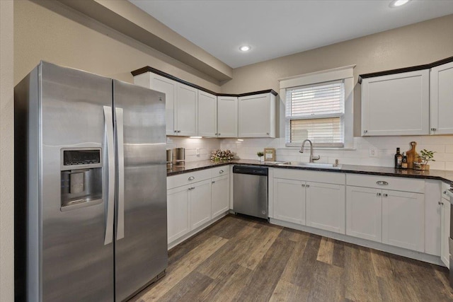 1721 E 12th Ave, Spokane, WA 99202 - kitchen featuring appliances with stainless steel finishes, a sink, decorative backsplash, dark wood-style flooring, and recessed lighting