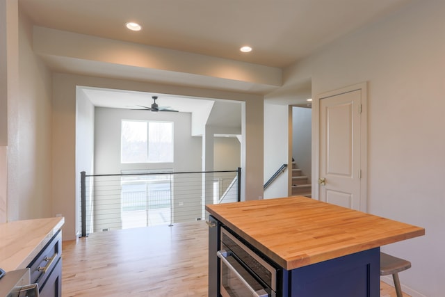 1810 W Summit Pkwy, Spokane, WA 99201 - kitchen featuring butcher block counters, blue cabinets, a kitchen breakfast bar, a ceiling fan, and light wood-style floors
