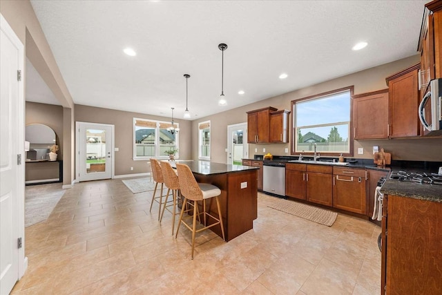 7708 N Warren Ln, Spokane, WA 99208 - kitchen with appliances with stainless steel finishes, a sink, a kitchen island, recessed lighting, and brown cabinetry