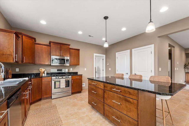 7708 N Warren Ln, Spokane, WA 99208 - kitchen with appliances with stainless steel finishes, a sink, a breakfast bar area, brown cabinets, and decorative light fixtures