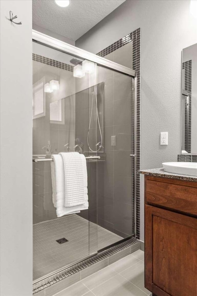 7708 N Warren Ln, Spokane, WA 99208 - bathroom with a shower stall, vanity, tile patterned flooring, and a textured ceiling