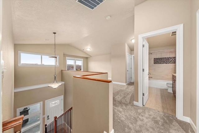 7708 N Warren Ln, Spokane, WA 99208 - corridor with an upstairs landing, carpet flooring, vaulted ceiling, baseboards, and a textured ceiling