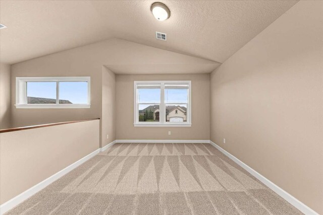 7708 N Warren Ln, Spokane, WA 99208 - empty room featuring carpet flooring, lofted ceiling, baseboards, and a textured ceiling