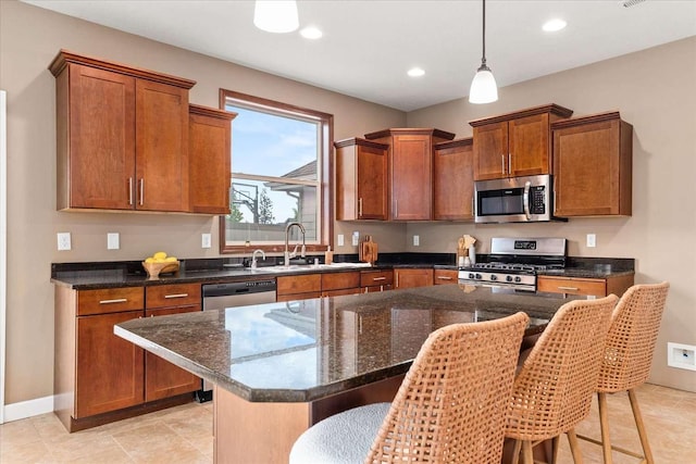 7708 N Warren Ln, Spokane, WA 99208 - kitchen with stainless steel appliances, a kitchen bar, brown cabinetry, a sink, and recessed lighting
