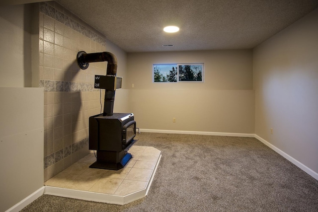 38821 N Newport Hwy, Elk, WA 99009 - detailed view of a wood stove, carpet floors, a textured ceiling, and baseboards