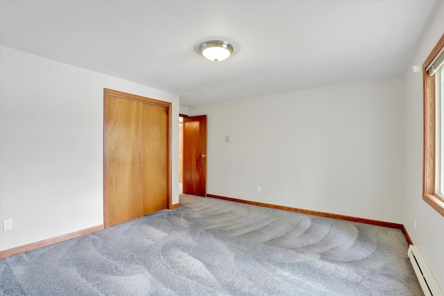13227 N E Newman Lake Dr, Newman Lake, WA 99025 - unfurnished bedroom with baseboard heating, carpet, a closet, and baseboards