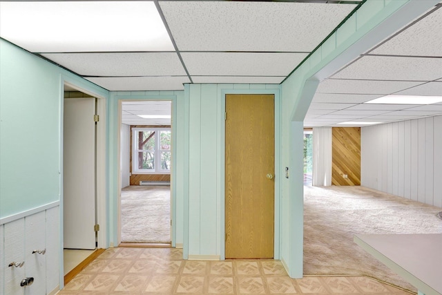 13227 N E Newman Lake Dr, Newman Lake, WA 99025 - corridor featuring a paneled ceiling, light carpet, wooden walls, a baseboard heating unit, and light flooring