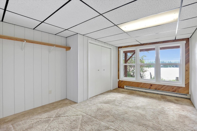 13227 N E Newman Lake Dr, Newman Lake, WA 99025 - unfurnished bedroom with a baseboard heating unit, carpet floors, a paneled ceiling, and wooden walls