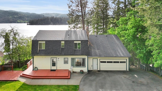 13227 N E Newman Lake Dr, Newman Lake, WA 99025 - rear view of property featuring driveway, an attached garage, roof with shingles, and a deck with water view