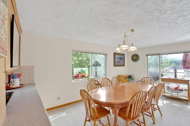 13227 N E Newman Lake Dr, Newman Lake, WA 99025 - dining area featuring light colored carpet, plenty of natural light, a chandelier, a textured ceiling, and baseboards