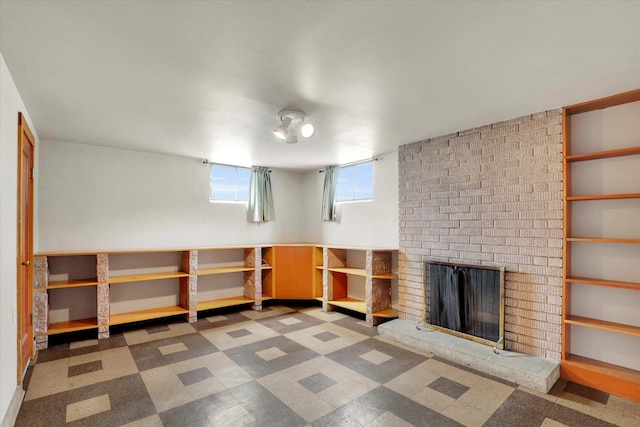 basement with tile patterned floors and a brick fireplace