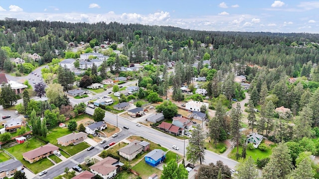 aerial overview of property's location featuring a forest and nearby suburban area