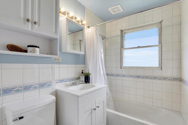 bathroom featuring shower / bath combination with curtain, toilet, tile walls, vanity, and tasteful backsplash