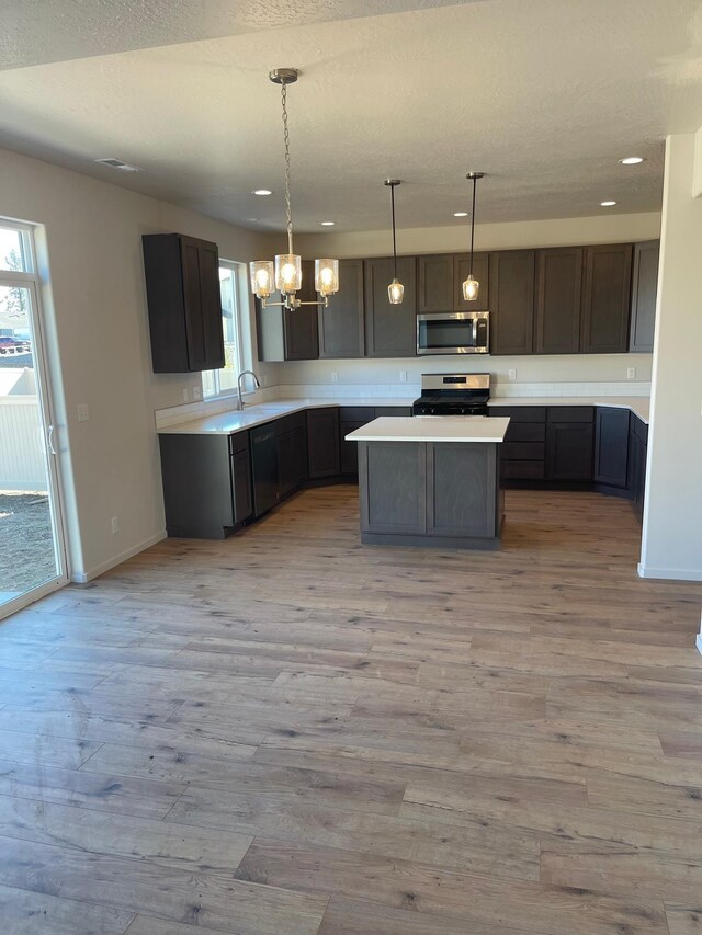 18718 E Riverside Ct, Spokane Valley, WA 99016 - kitchen with appliances with stainless steel finishes, plenty of natural light, a chandelier, a kitchen island, and recessed lighting