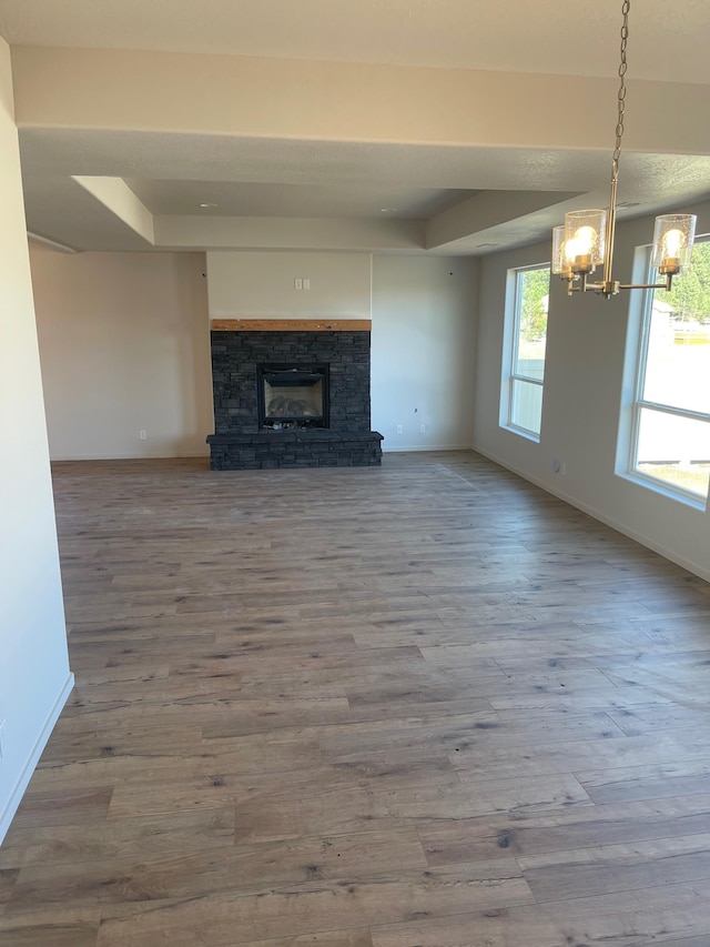 18718 E Riverside Ct, Spokane Valley, WA 99016 - unfurnished living room with a chandelier, baseboards, wood finished floors, and a fireplace