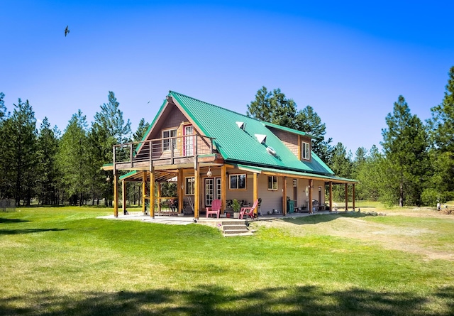 back of house with a lawn, metal roof, and a patio