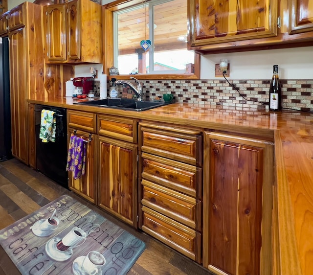 kitchen with a sink, butcher block counters, black appliances, and brown cabinetry