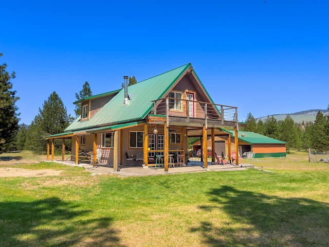 back of property with a lawn, a patio area, metal roof, and a wooden deck