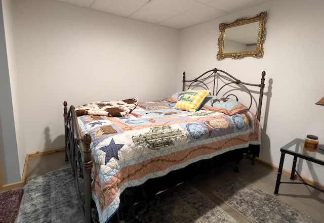 bedroom featuring baseboards and a paneled ceiling