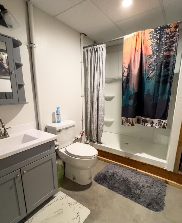full bathroom with a shower stall, concrete floors, toilet, vanity, and a drop ceiling