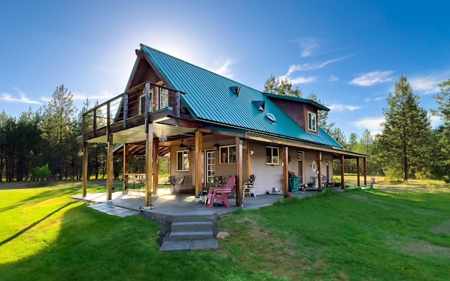 20 River Ranch Rd, Kettle Falls, WA 99141 - rear view of house with a lawn, a patio area, and metal roof