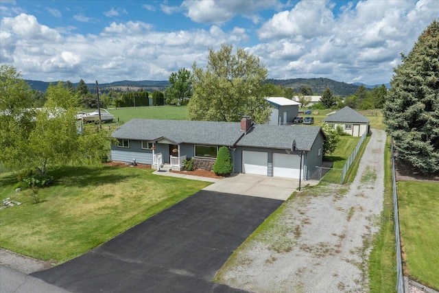 24005 E Garland Ave, Otis Orchards, WA 99027 - ranch-style home featuring an attached garage, asphalt driveway, a mountain view, and a chimney