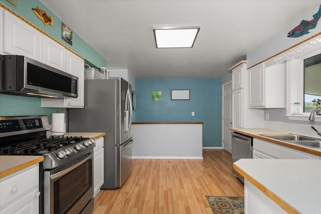 24005 E Garland Ave, Otis Orchards, WA 99027 - kitchen with appliances with stainless steel finishes, a sink, white cabinets, and light wood finished floors