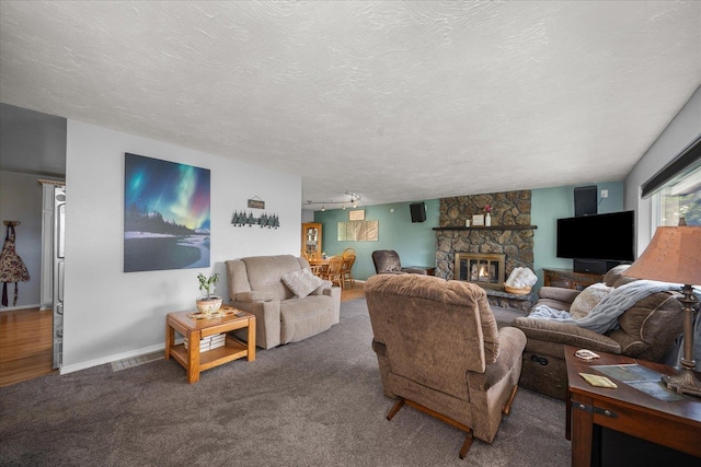 24005 E Garland Ave, Otis Orchards, WA 99027 - carpeted living area featuring a fireplace, a textured ceiling, and baseboards