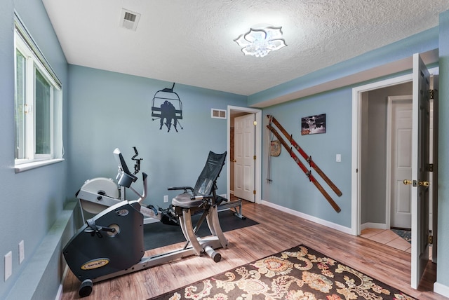 4109 S Hollow Ct, Spokane, WA 99206 - workout room with wood finished floors, a textured ceiling, and baseboards