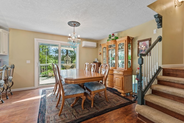 4109 S Hollow Ct, Spokane, WA 99206 - dining room featuring an AC wall unit, a chandelier, wood finished floors, stairs, and a textured ceiling