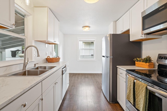 3424 W Princeton Ave, Spokane, WA 99205 - kitchen featuring appliances with stainless steel finishes, a sink, white cabinetry, dark wood-style flooring, and baseboards