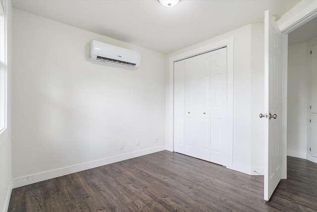 3424 W Princeton Ave, Spokane, WA 99205 - unfurnished bedroom featuring an AC wall unit, dark wood finished floors, baseboards, and a closet