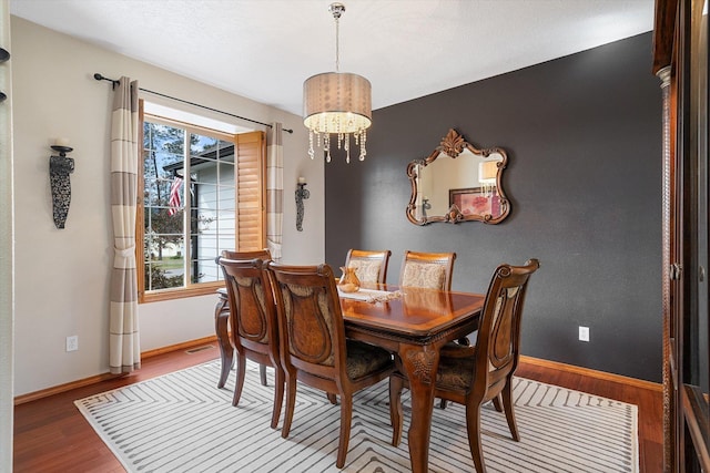 6482 Lakeview Dr, Nine Mile Falls, WA 99026 - dining room with a chandelier, wood finished floors, and baseboards
