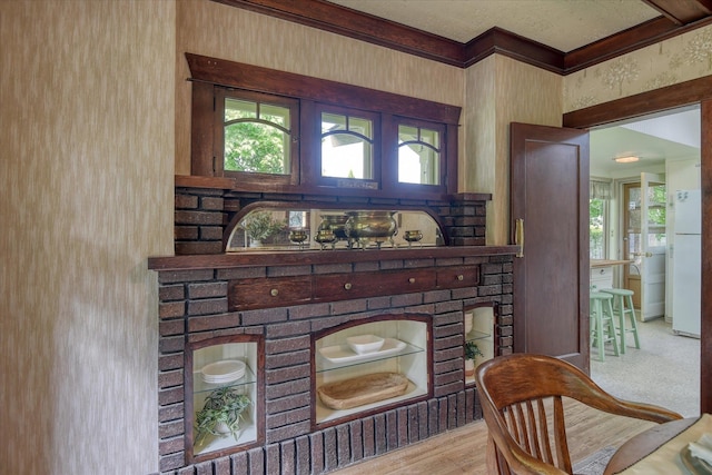 detailed view of freestanding refrigerator, ornamental molding, and wood finished floors