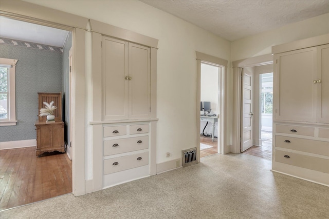 bedroom with baseboards, wallpapered walls, and a textured ceiling