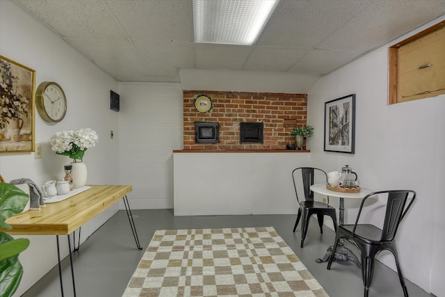 dining room featuring finished concrete floors and a drop ceiling