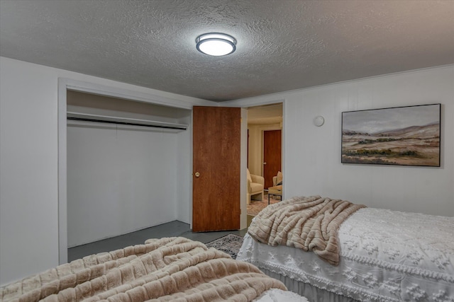 bedroom featuring a closet, finished concrete floors, and a textured ceiling