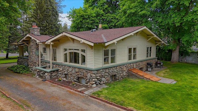 10228 N Whitworth Dr, Spokane, WA 99218 - view of front facade featuring stone siding, a front yard, and a chimney