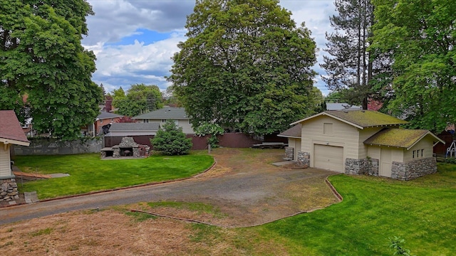 view of front of house featuring a garage, stone siding, driveway, a front lawn, and a chimney