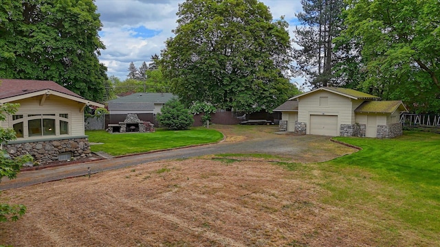 view of green lawn featuring asphalt driveway