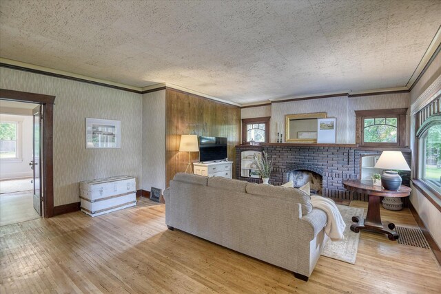 10228 N Whitworth Dr, Spokane, WA 99218 - living area with wood-type flooring, crown molding, healthy amount of natural light, and a fireplace