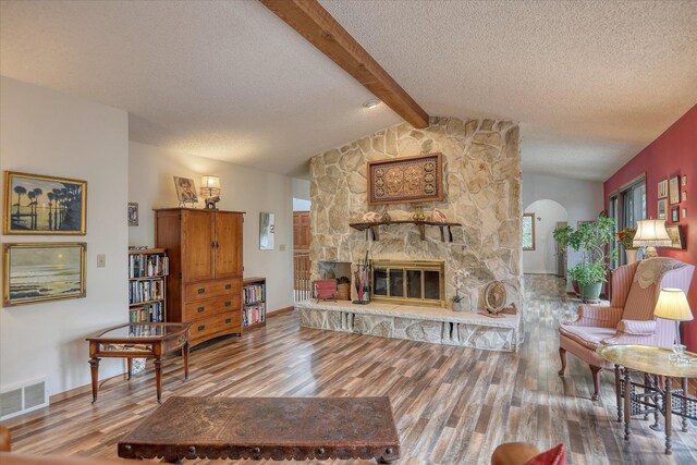 8410 E Columbia Park Dr, Spokane, WA 99212 - living room with wood finished floors, arched walkways, a textured ceiling, a fireplace, and baseboards