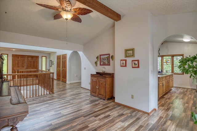 8410 E Columbia Park Dr, Spokane, WA 99212 - living area with arched walkways, wood finished floors, ceiling fan, a textured ceiling, and baseboards
