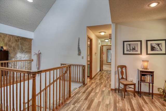 8410 E Columbia Park Dr, Spokane, WA 99212 - hall featuring an upstairs landing, a textured ceiling, light wood-type flooring, high vaulted ceiling, and baseboards