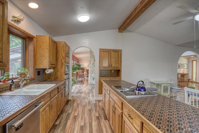 8410 E Columbia Park Dr, Spokane, WA 99212 - kitchen featuring stainless steel appliances, arched walkways, a sink, and light wood finished floors
