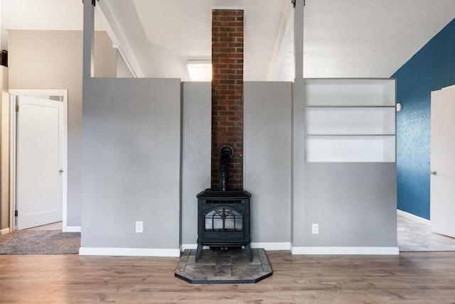 3123 E 36th Ave, Spokane, WA 99223 - unfurnished living room featuring wood finished floors, baseboards, and a wood stove
