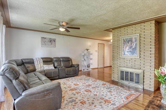 9509 N Atlantic St, Spokane, WA 99218 - living area featuring crown molding, ceiling fan, a textured ceiling, wood finished floors, and a brick fireplace