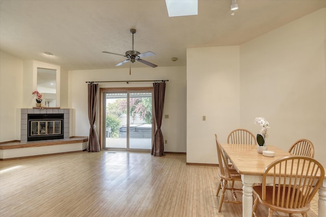 6923 N Hamilton St Unit 6923, Spokane, WA 99208 - dining area featuring light wood finished floors, baseboards, a tiled fireplace, and a ceiling fan