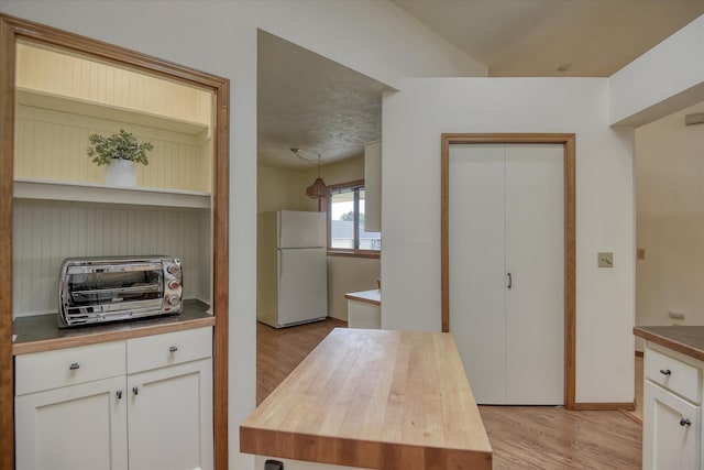 6923 N Hamilton St Unit 6923, Spokane, WA 99208 - kitchen with freestanding refrigerator, wooden counters, light wood-style floors, and white cabinets