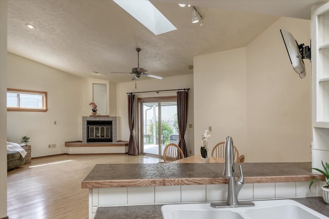 6923 N Hamilton St Unit 6923, Spokane, WA 99208 - kitchen with a sink, healthy amount of natural light, light wood-style floors, a fireplace, and lofted ceiling